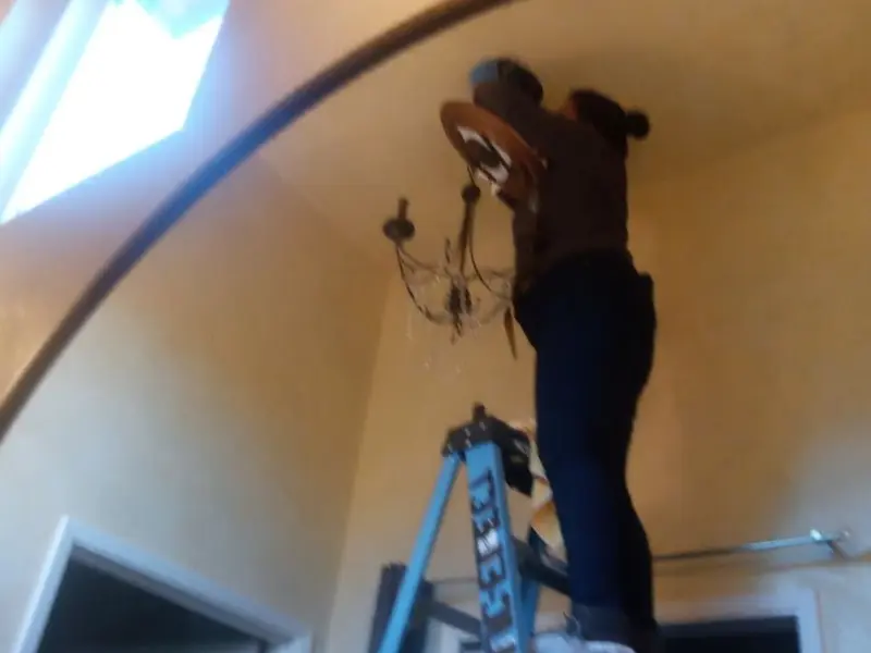 Electrician installing a chandelier in a Glendora residence